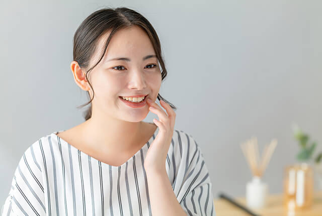 歯を見せて微笑んでいる女性