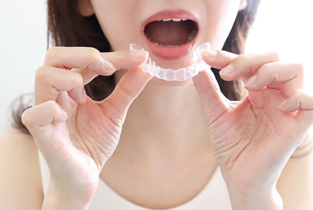 マウスピースをはめようとしている女性